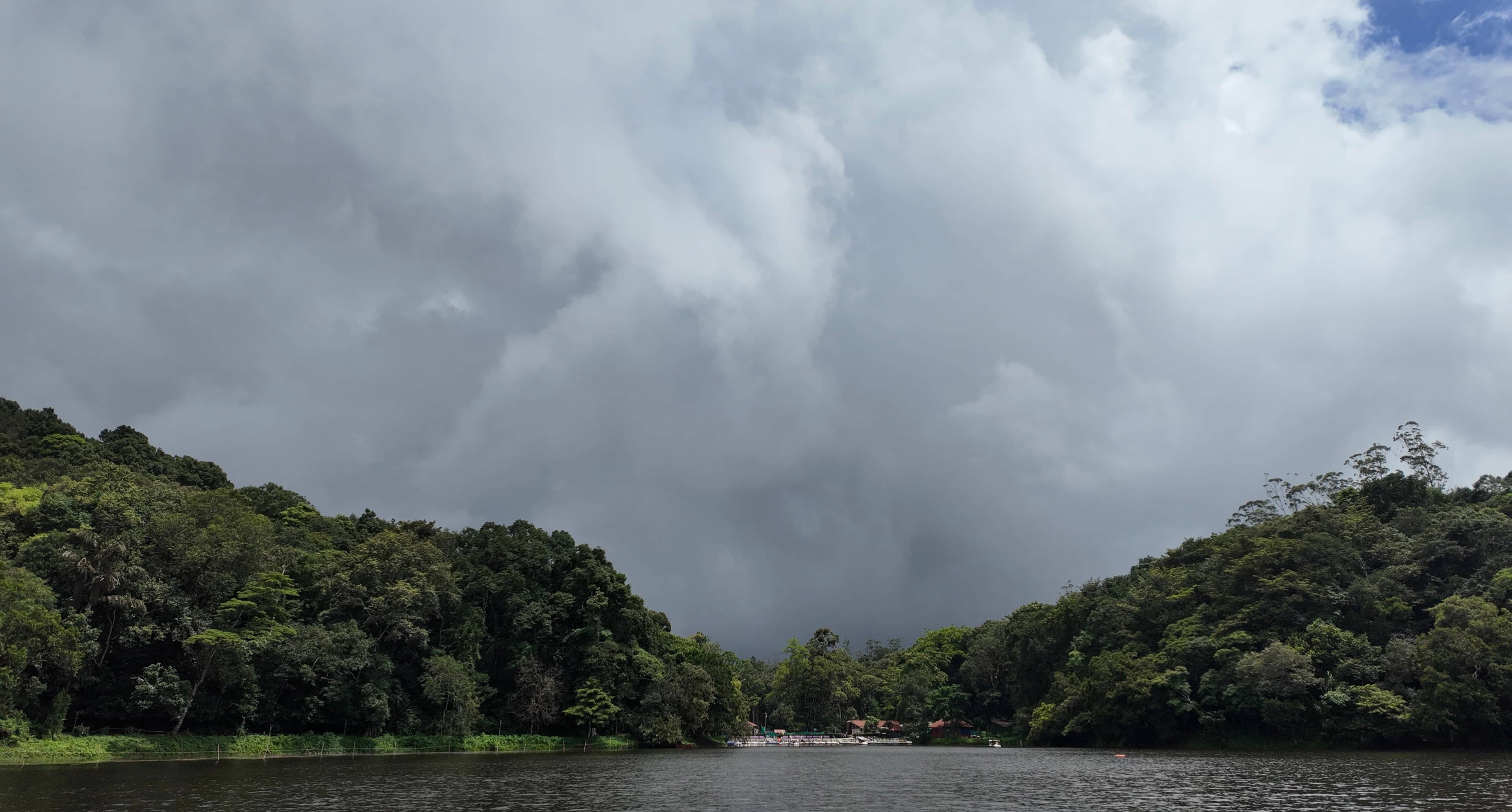 Storm clouds gathering over a forested lake